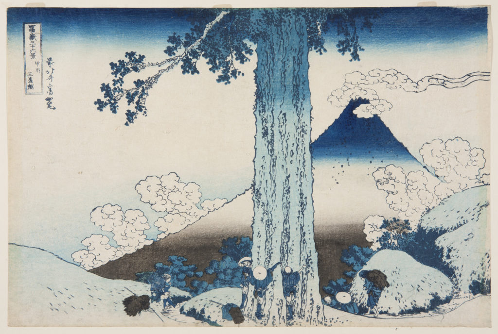 Japanese landscape. A trunk of a large tree in the centre with a group of people, in traditional dress, surrounding it having laid their packs down. Behind the tree travellers disappear down the path. Mount Fuji rises up in the background with fluffy clouds surrounding it.