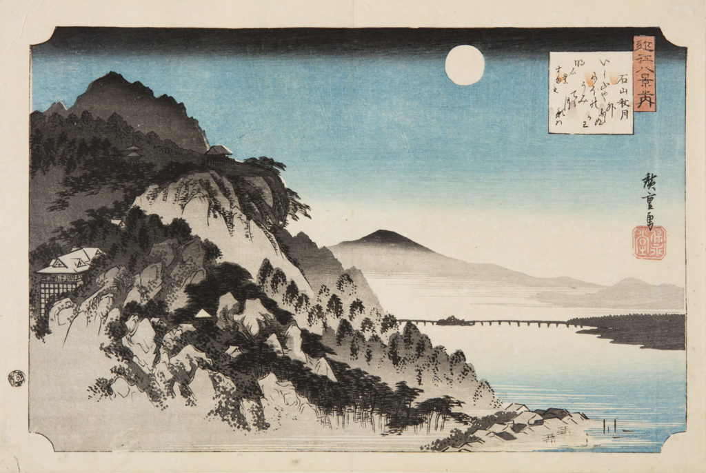 Japanese print of a landscape, to the left is a small building nestled in high wooded hills, to the right is a river, a distant bridge and Mount Fuji and the full moon rising behind.