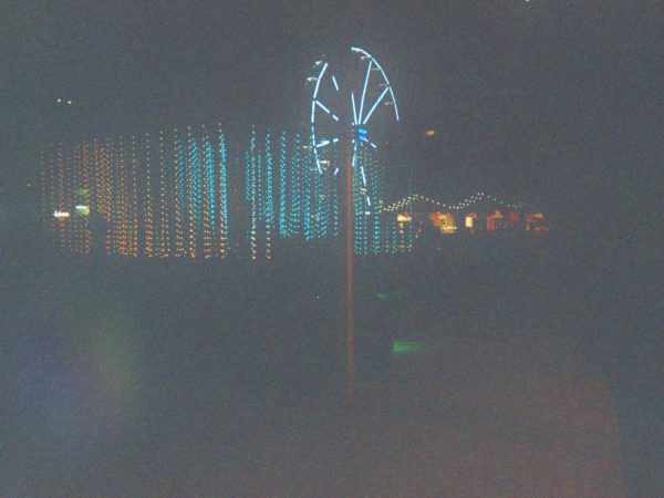 Lydia's photograph (for the 21st Century Kids) of millennium square in the dark with buildings and the ferris wheel lit up