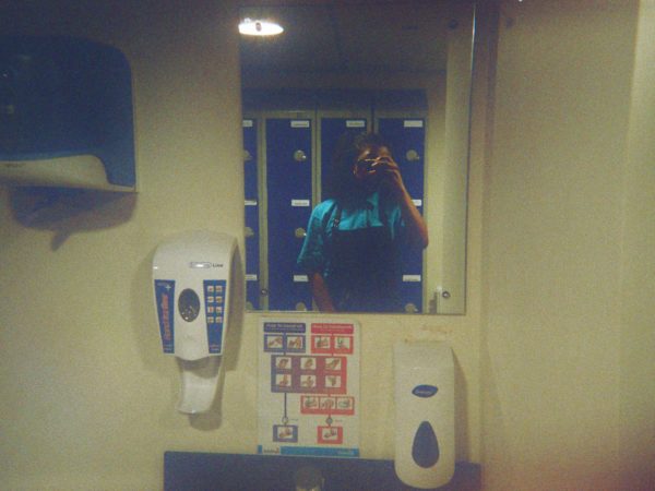 Lydia's photograph (for the 21st Century Kids) of herself taking a picture in the mirror of the bathroom. She is wearing a uniform