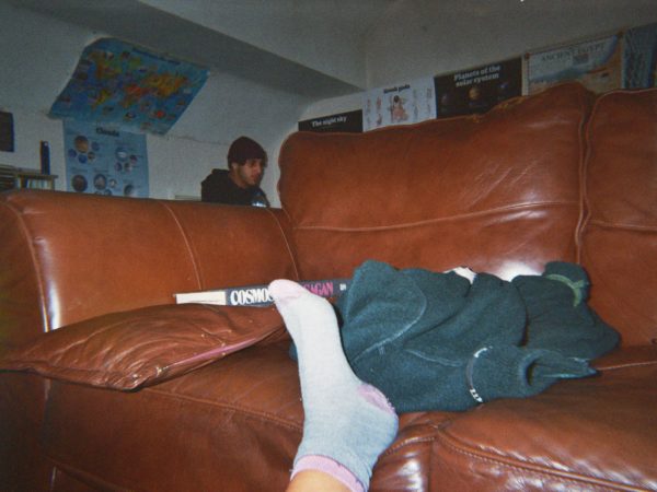 Beatriz's photograph (for the 21st Century Kids) of her friend in the background behind the sofa with is at the foreground of the image. Beatriz's foot is resting on the sofa.