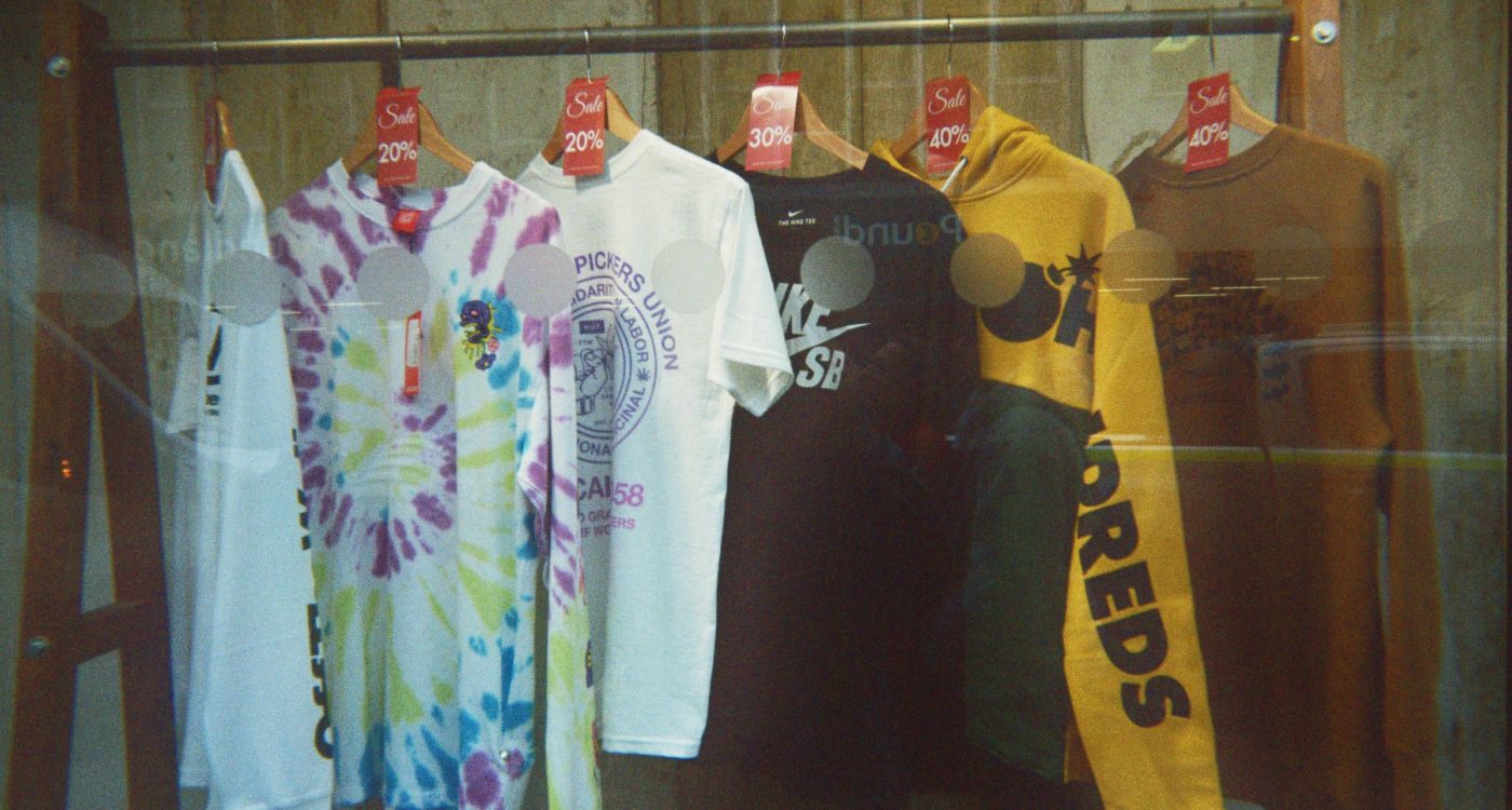 Brooke's disposable photograph (for the 21st Century Kids) of a shop front with a range of T-shirts and hoodies on a rail.