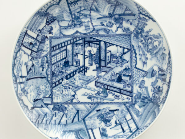 blue and white dish depicting porcelain production in the town of Arita in the 1830s. Thirty-four artisans perform over twenty different jobs, from making porcelain clay to firing vessels