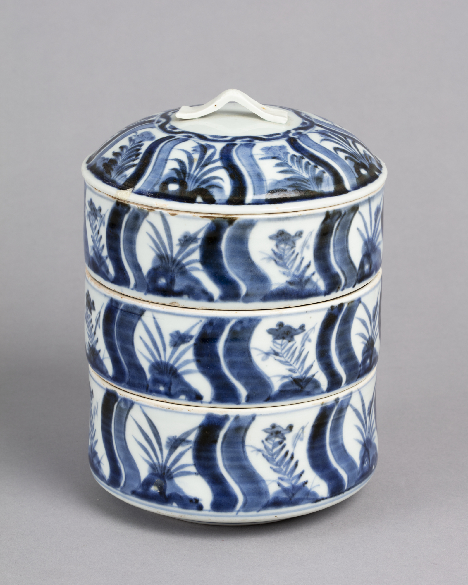Tiered lidded box with design of rocks and flowers in blue on white