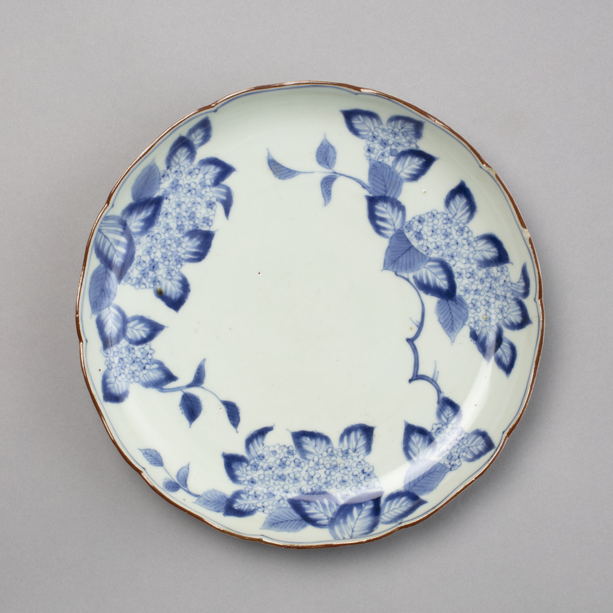 Dish with hydrangea design in blue on white with a gold edge