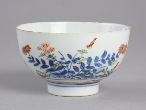 Bowl with design of flowers and grasses in blue, orange and green paint