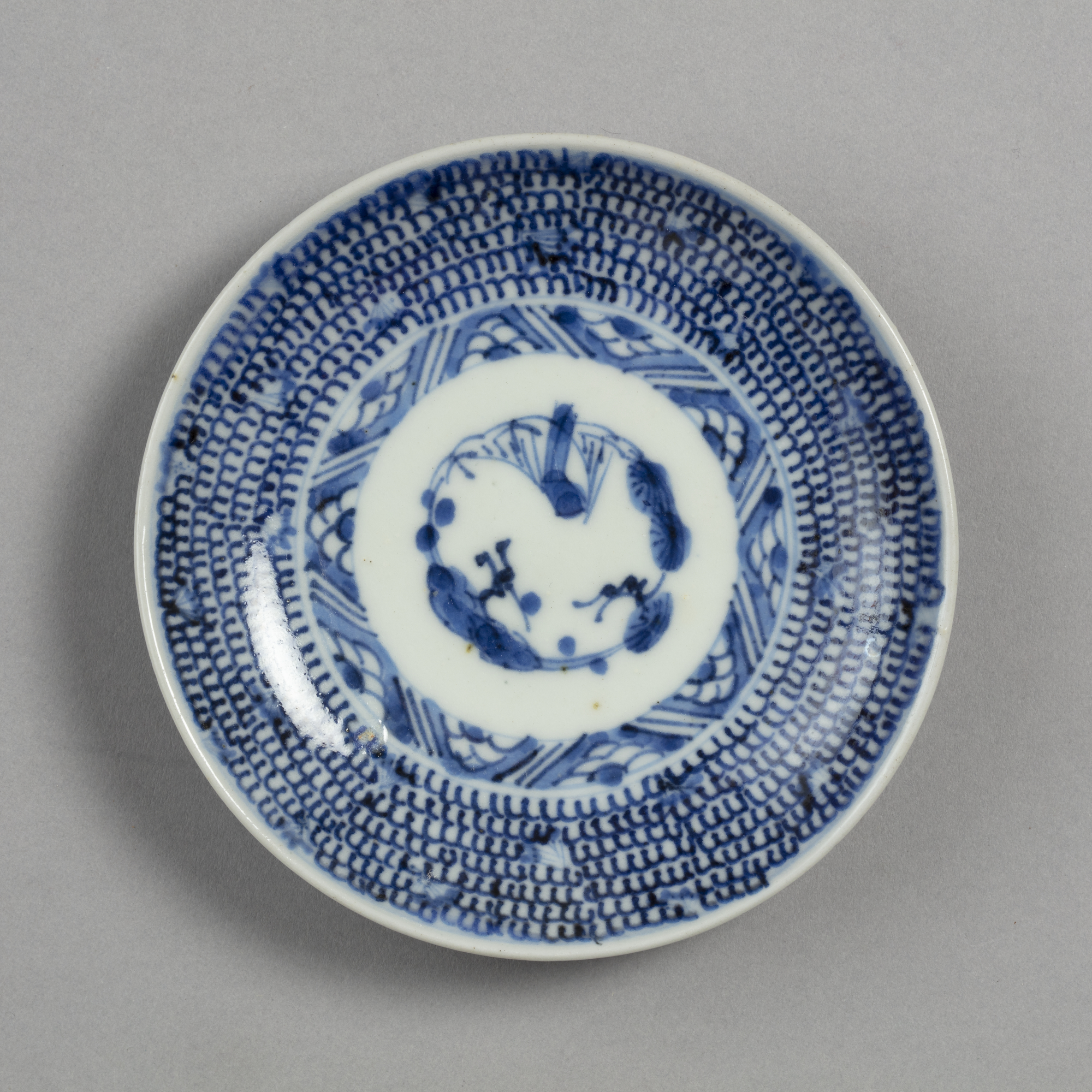 Small dish with blue on white design of plum, pine, and bamboo