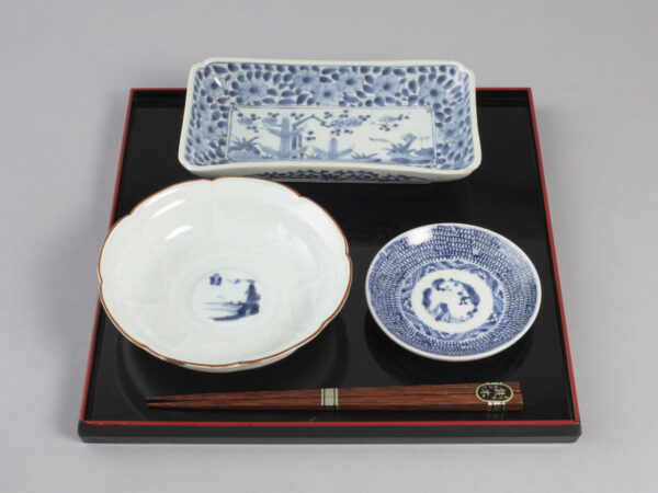 a tray setup with a bowl, plate and rectangular dish on a wooden tray