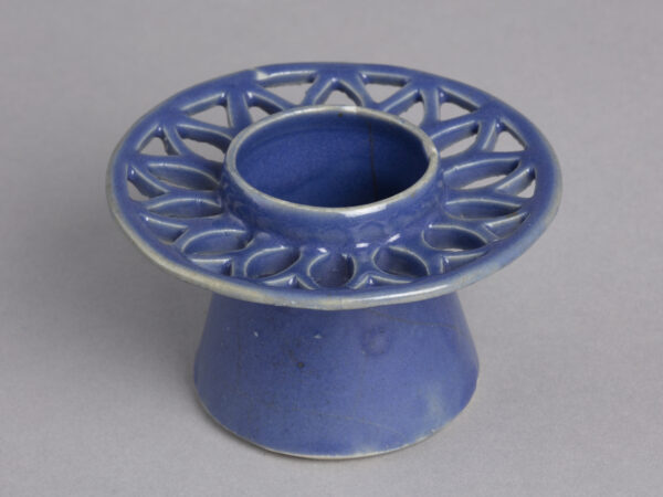Blue cup stand with openwork (patterned holes which make a design)