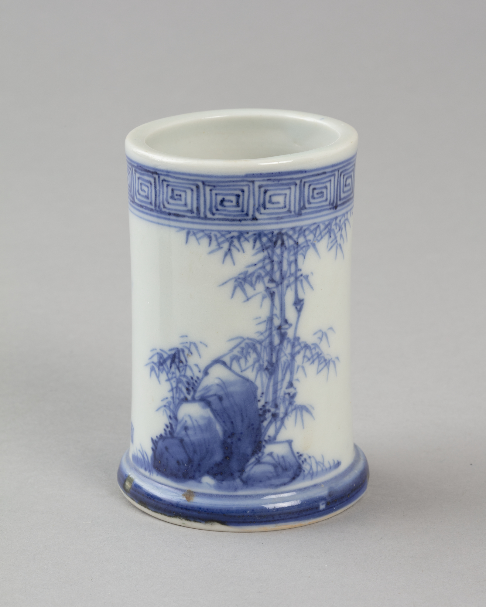 Brush pot with blue on white design of rocks and bamboo