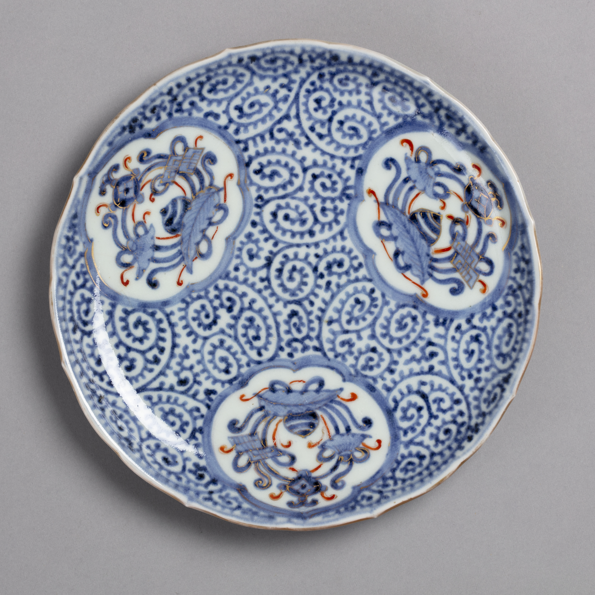 Dish with octopus scroll pattern in blue and orange on white