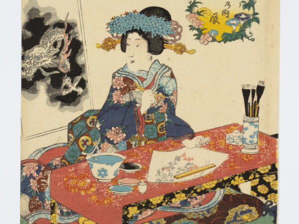 woman in a woodblock print uses small porcelain dishes to hold the ink for a fan painting and a larger porcelain bowl to wash her brushes. A ceramic brush pot and water dropper sits on her desk