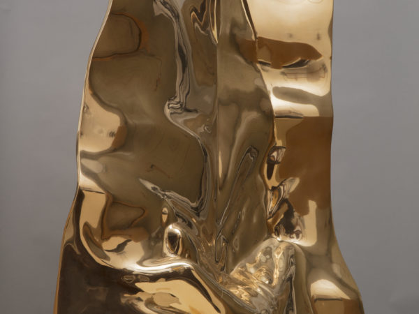 A bronze sub-rectangular sculpture with wide ripples and folds.