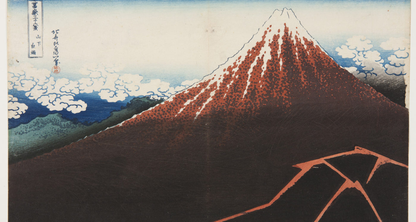 Japanese print of Mount Fuji, dramatic in dark red, snow at the summit and fluffy clouds surrounding it.