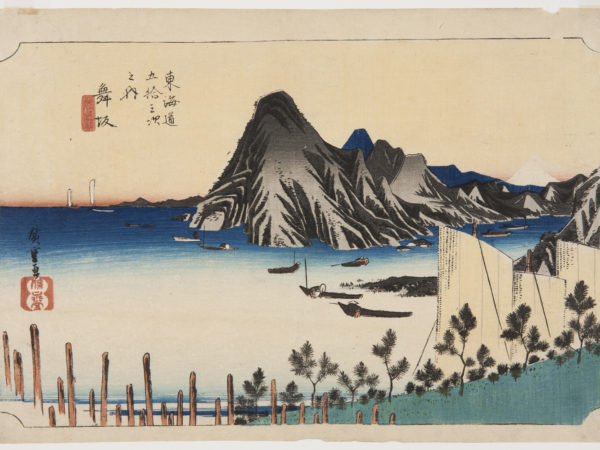 A Japanese print of a landscpe. Small boats on the water with mountainous land in the background.