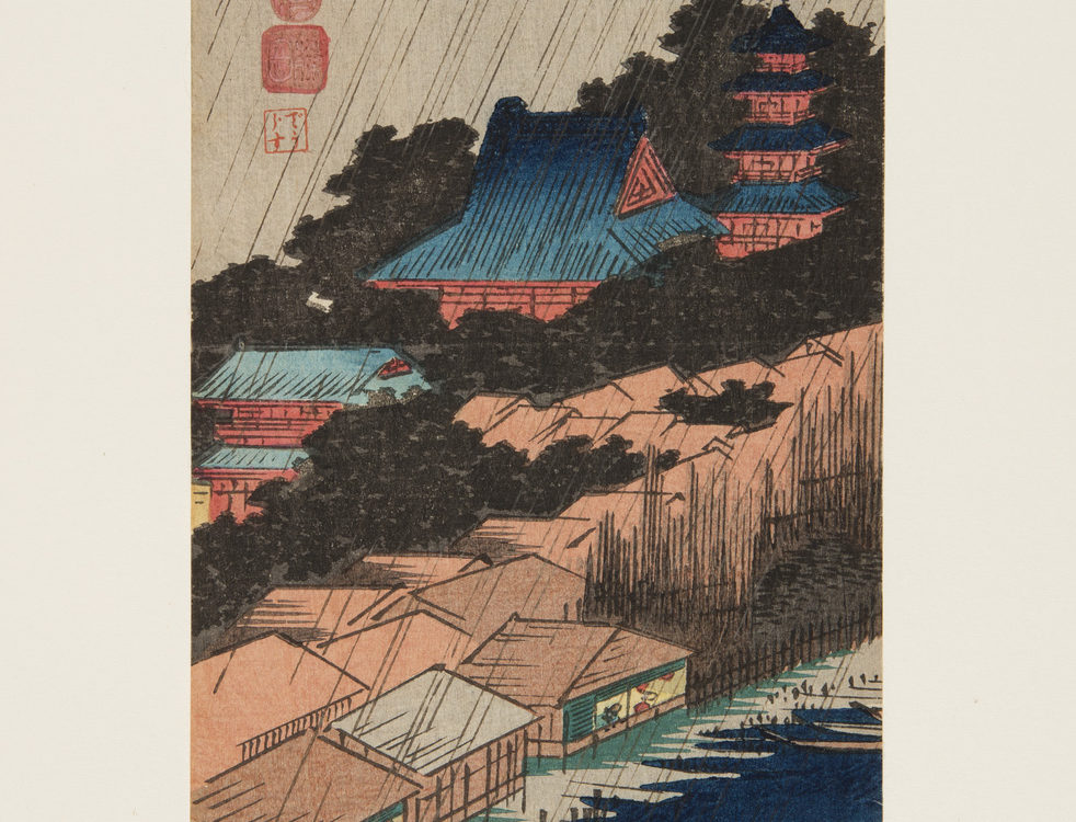 Japanese print of a landscape. in the foreground is water with boats, the shoreline has buildings, behind these are trees and a temple on a hill. Rain slants top right, bottom left, across the scene.