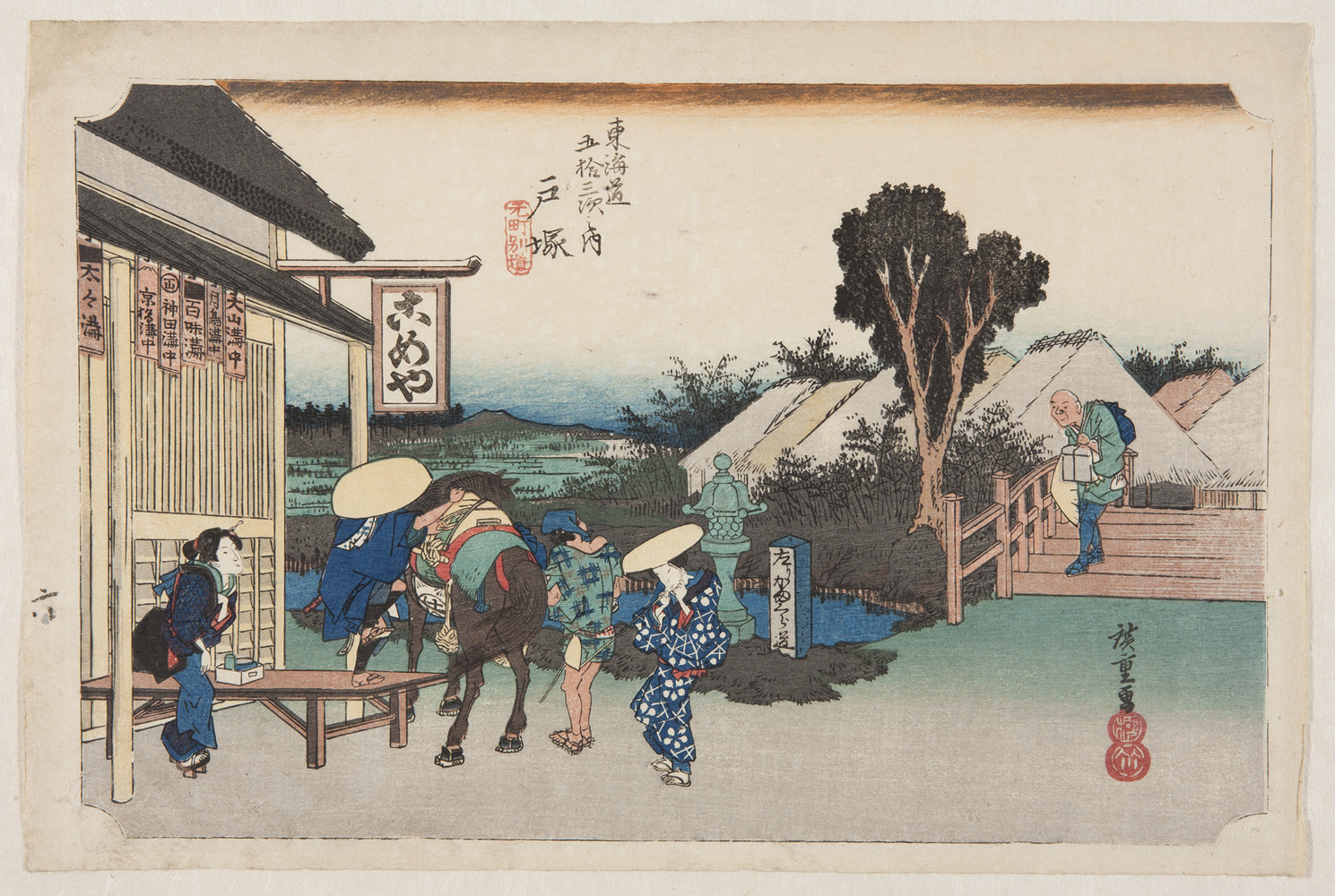Japanese print of travellers outside an inn. A man, foot in stirrup, prepares to mount a horse, an attendant stands at the side. Two women in elaborate traditional dress look on. A man carrying a box walks down the steps towards the group. In the background are more buildings and countryside beyond.