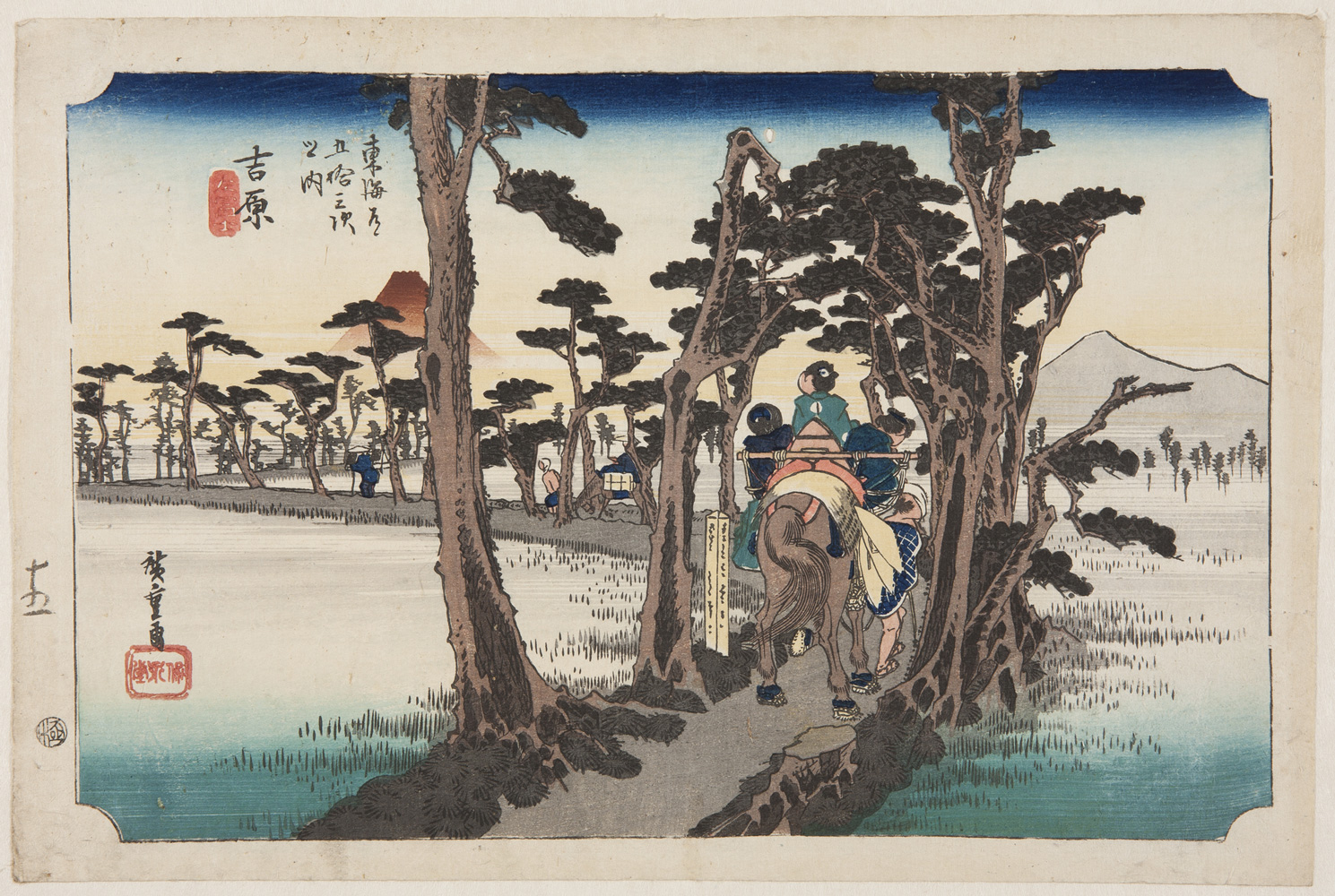 japanese print of travellers on a horse walking through a road lined with trees which zig zags through a marshy area. there are mountains in the background