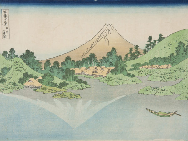 Japanese print of a landscape showing the reflection of the mountain in Lake Misaka. In the foreground is the calm lake and a small boat. In the mid distance is the shore with green hills, inlets and villages. The mountain rises up behind.