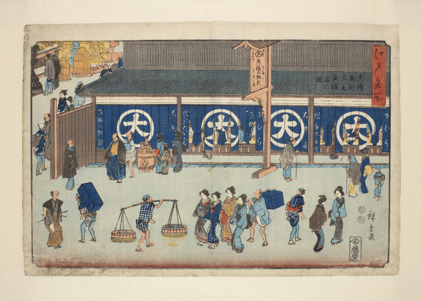 Japanese print of a lively street scene. People dressed in traditional clothes walk in front of a building; a man carries a box on his back, another has a pole on his shoulder with two baskets at each end, a group of well-dressed women walk along with a male servant carrying a box following, two women stop and talk to each other.