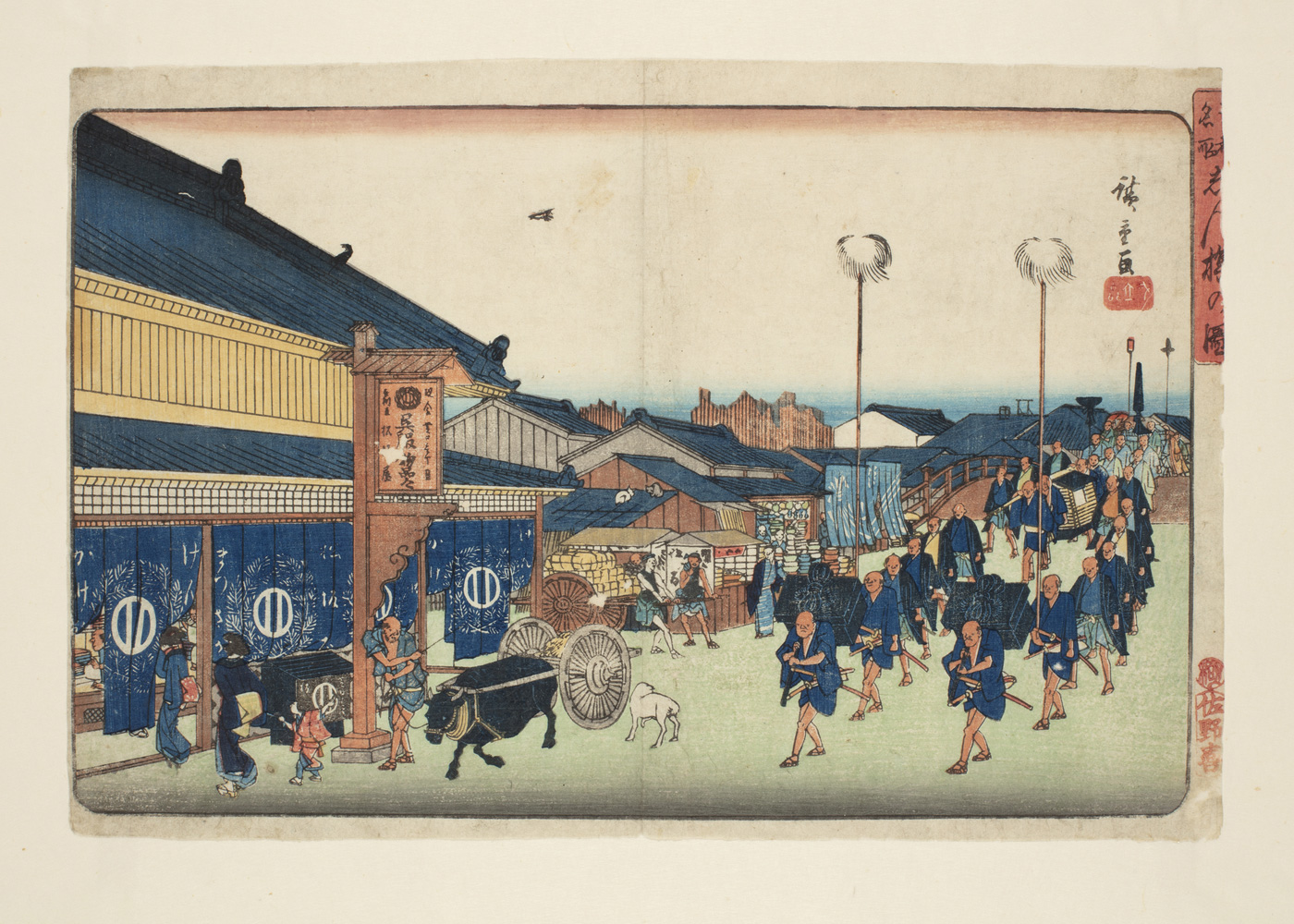 Japanese print of a procession along a street, with buildings and the sea on the horizon. In the foreground is an ox pulling a cart with a driver by its side, behind men, in rows, carry trunks on their backs, others carry tall poles, the procession recedes back over a bridge and into the distamce.