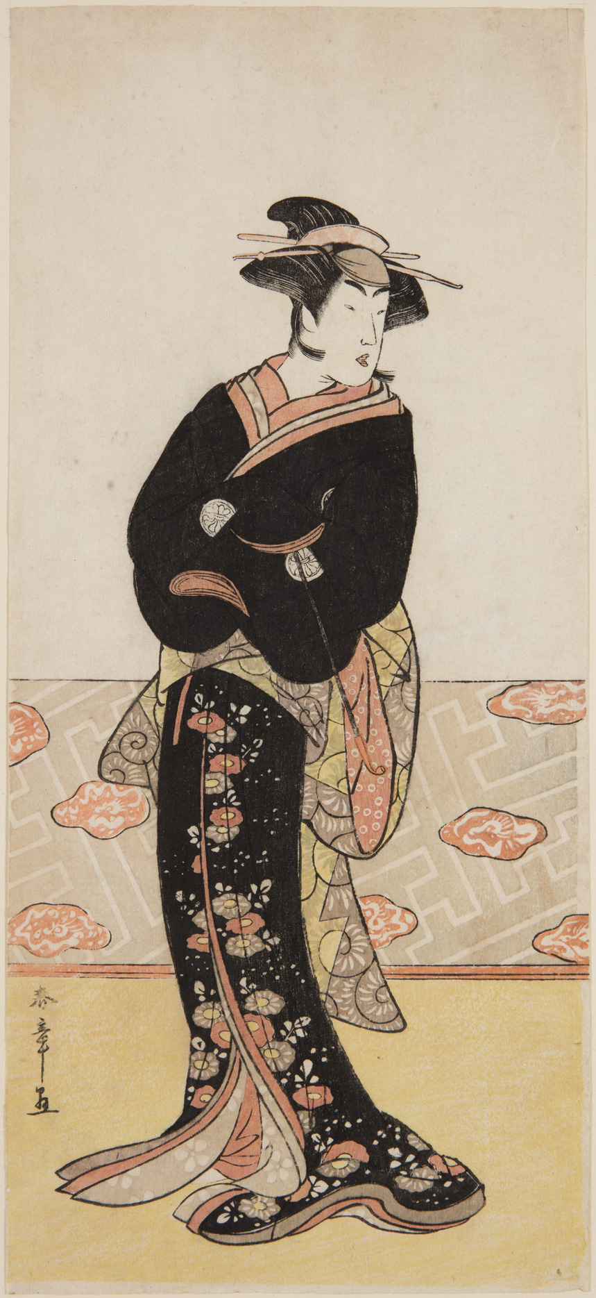 A japanese print of an actor dressed in a black kimono, arms folded and looking to the side.