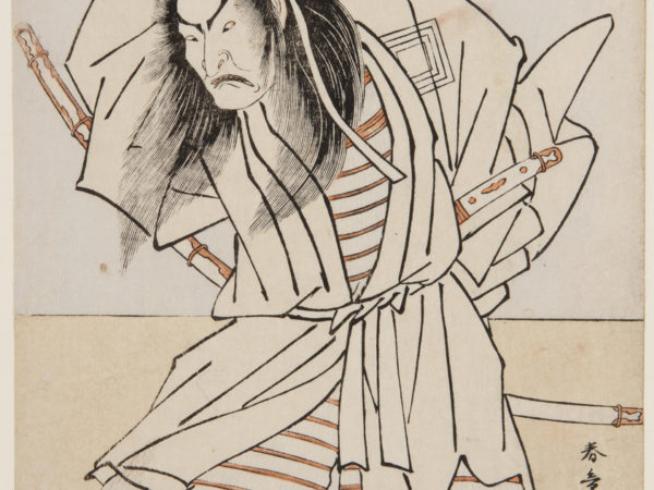 A Japanese print of an actor posed legs bent, looking down. He is wearing samurai traditional robes with his swords and staff in the back of his belt.