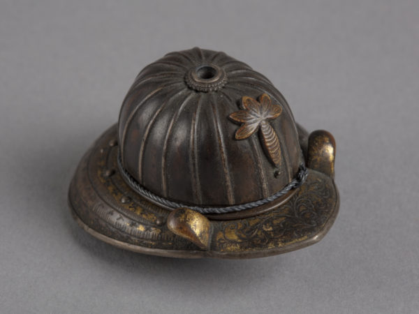 A Japanese metal netsuke of a Kabuto, a metal helmet worn by samurai soldiers.