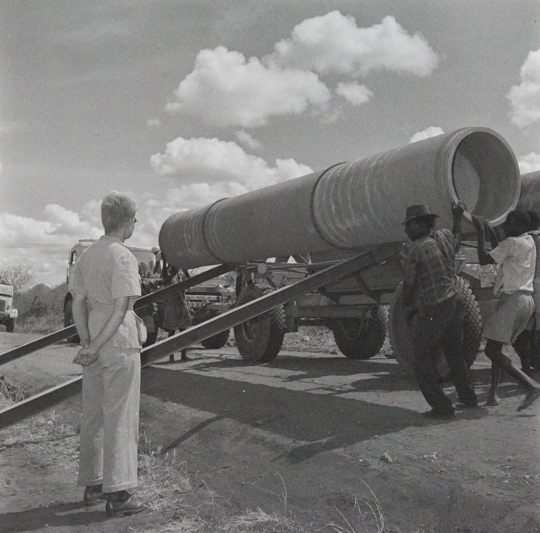 Marie Lindley watches Kenyan workers unloading water pipes. Bristol Archives, BEC collection, 2001/090/1/1/5192