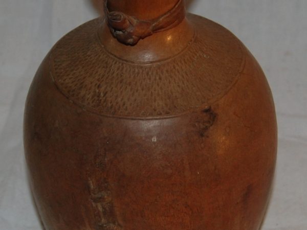 Colour photo of a carved wooden water bottle.